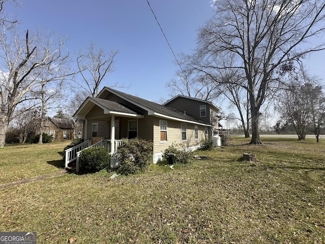 view of side of property with a yard and a porch