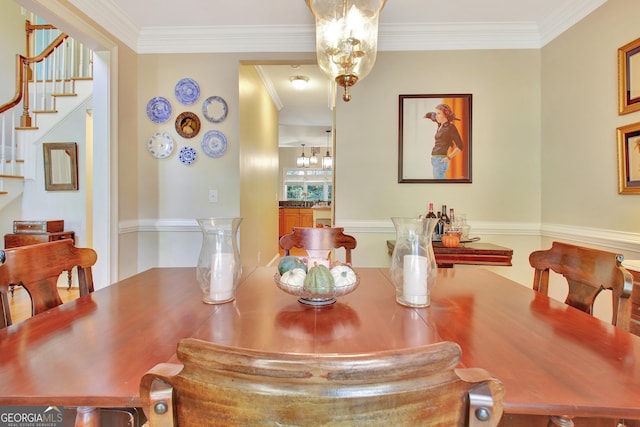 dining room with stairway, a chandelier, and ornamental molding