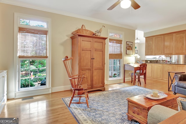 living room featuring crown molding, visible vents, and light wood-style floors