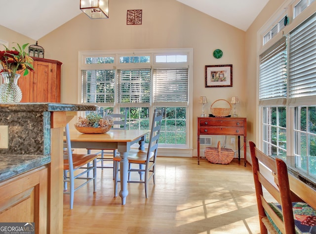 dining room with lofted ceiling, light wood-style flooring, and a chandelier