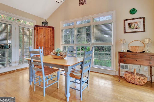 dining room with lofted ceiling, visible vents, and light wood finished floors