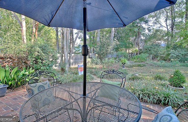 view of patio featuring outdoor dining area and fence