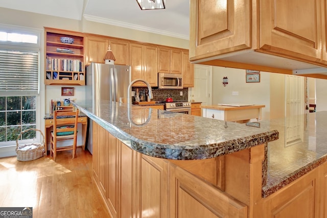 kitchen with a healthy amount of sunlight, light wood finished floors, stainless steel appliances, and crown molding