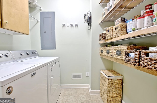 laundry area featuring baseboards, cabinet space, electric panel, and washer and dryer