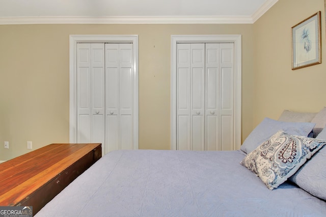 bedroom with multiple closets and ornamental molding