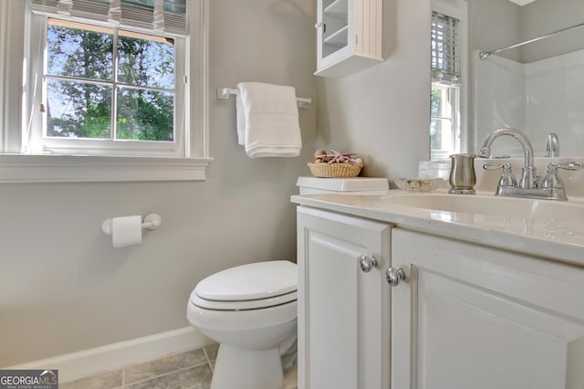 bathroom with baseboards, vanity, toilet, and tile patterned floors