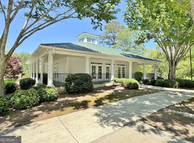 view of front of property featuring covered porch, metal roof, french doors, and a standing seam roof