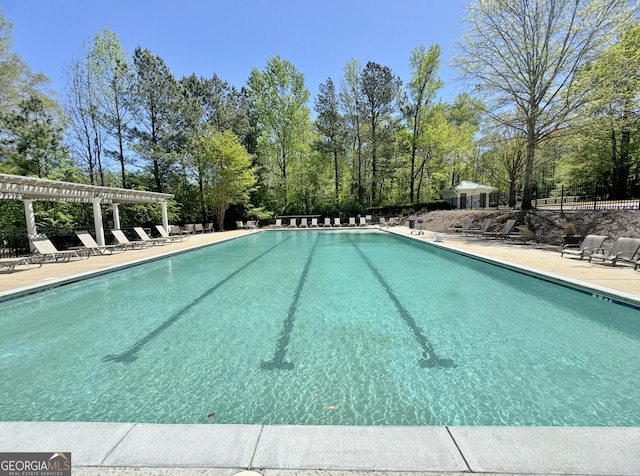 community pool featuring fence, a pergola, and a patio