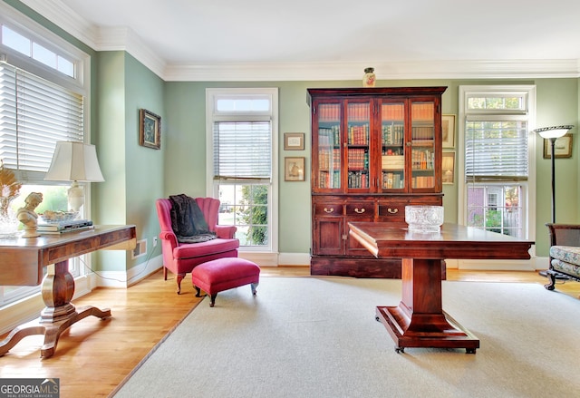 living area with light wood-style floors, baseboards, and ornamental molding