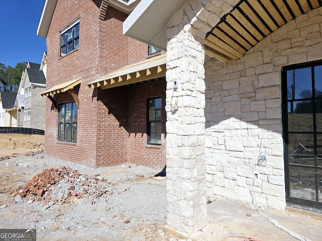 view of property exterior with stone siding and brick siding