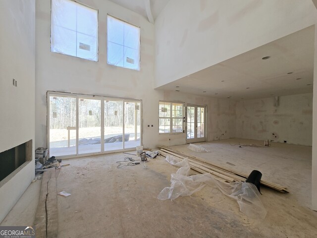 unfurnished living room featuring a high ceiling and a fireplace