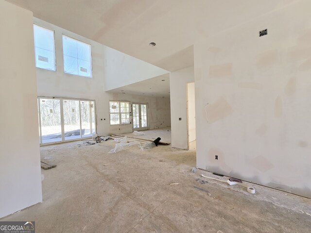 unfurnished living room with a towering ceiling