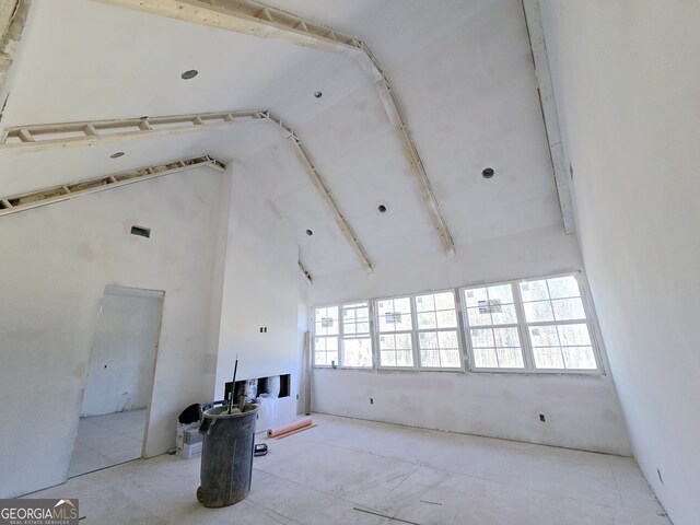 unfurnished living room with high vaulted ceiling