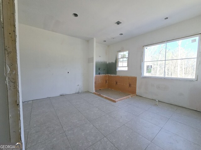 tiled empty room featuring visible vents