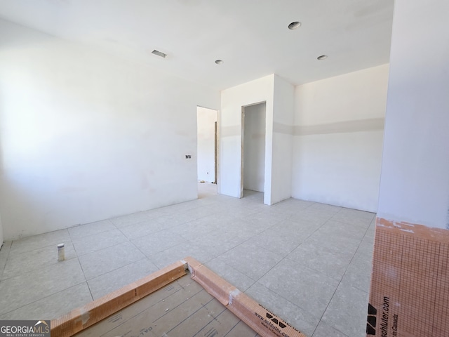 empty room with light tile patterned flooring and visible vents