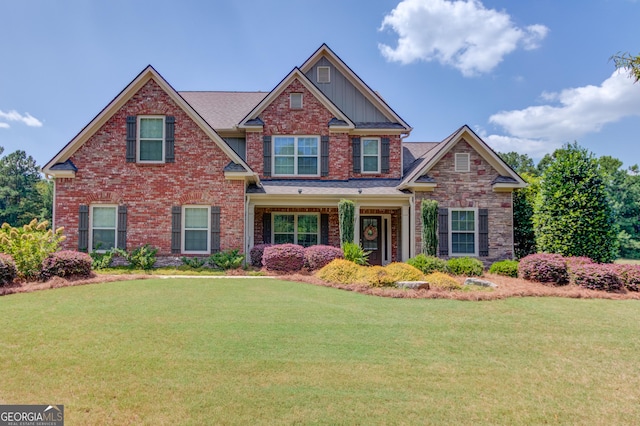 craftsman-style house featuring brick siding and a front yard