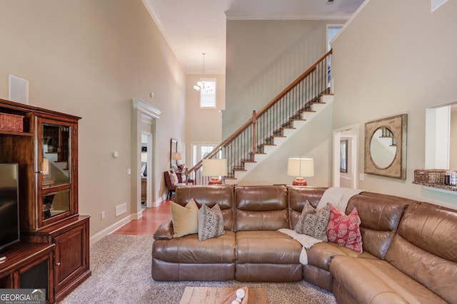 1433 Henderson Ridge Ln, Loganville, GA 30052 - living room with crown molding, stairway, a high ceiling, a chandelier, and baseboards