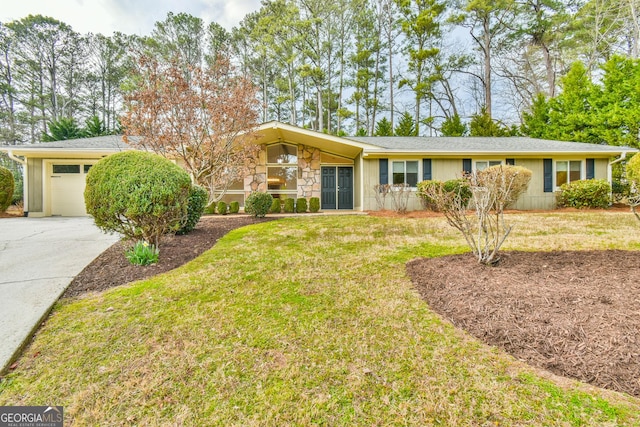 view of front of property featuring a garage, stone siding, concrete driveway, and a front yard