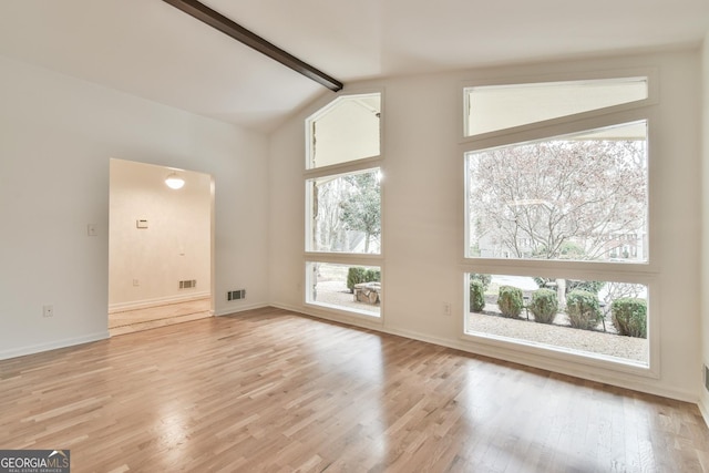 unfurnished living room with visible vents, light wood-style flooring, vaulted ceiling with beams, and a healthy amount of sunlight