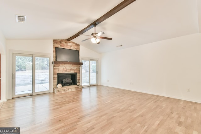 unfurnished living room with visible vents, light wood-style flooring, a ceiling fan, lofted ceiling with beams, and a stone fireplace