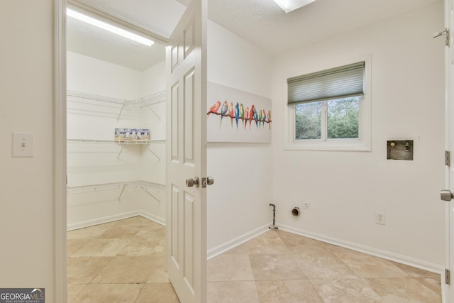 washroom with baseboards, gas dryer hookup, washer hookup, and laundry area