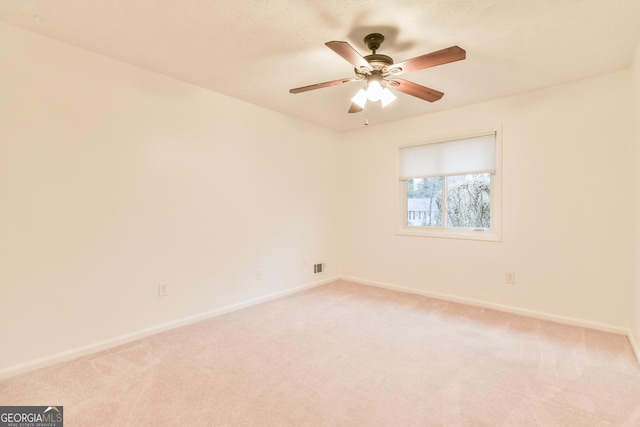 unfurnished room featuring light carpet, visible vents, ceiling fan, and baseboards