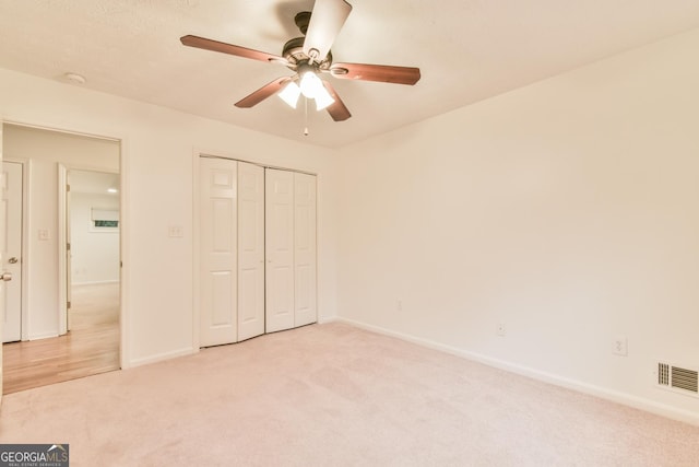 unfurnished bedroom with light carpet, visible vents, and baseboards