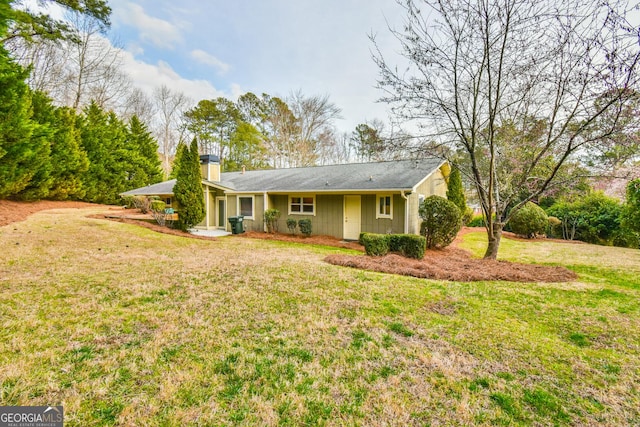 view of front of property featuring a chimney and a front lawn