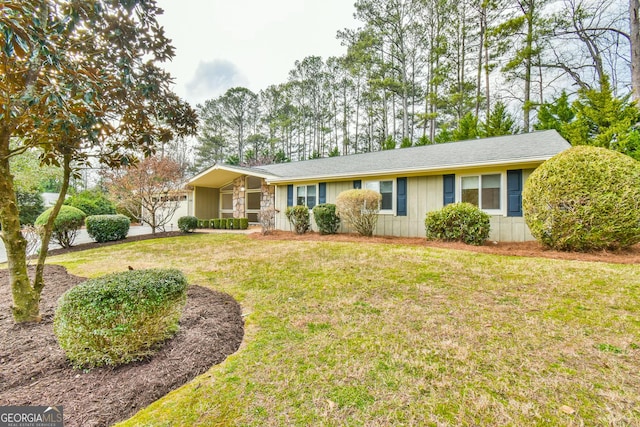 ranch-style home with a garage, board and batten siding, and a front yard