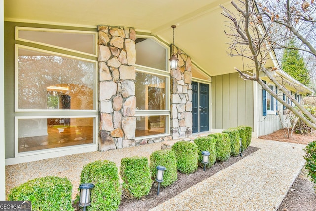 property entrance with stone siding and board and batten siding