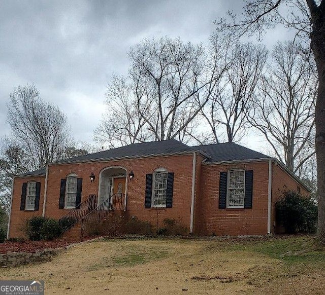 view of front of property with brick siding and a front lawn