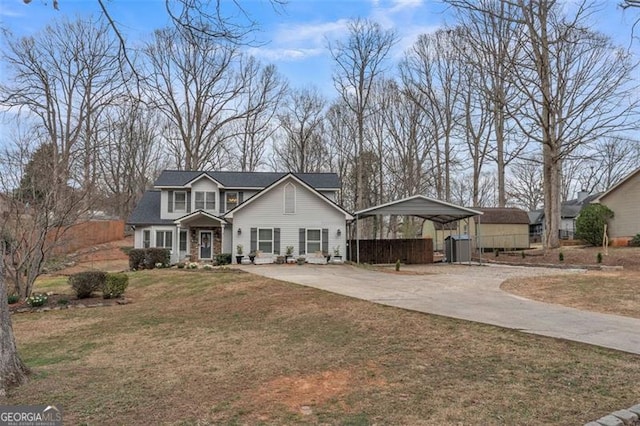 traditional-style home featuring driveway, a front yard, and a detached carport