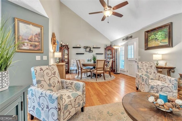 interior space featuring light wood-style floors, ceiling fan, and high vaulted ceiling