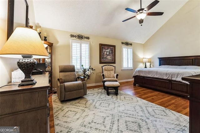 bedroom featuring lofted ceiling, multiple windows, wood finished floors, and baseboards