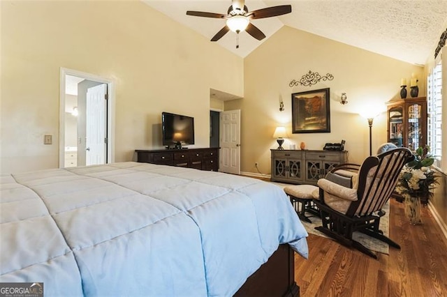 bedroom featuring ceiling fan, connected bathroom, a textured ceiling, wood finished floors, and high vaulted ceiling