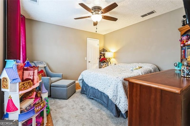 carpeted bedroom with a ceiling fan, visible vents, and a textured ceiling