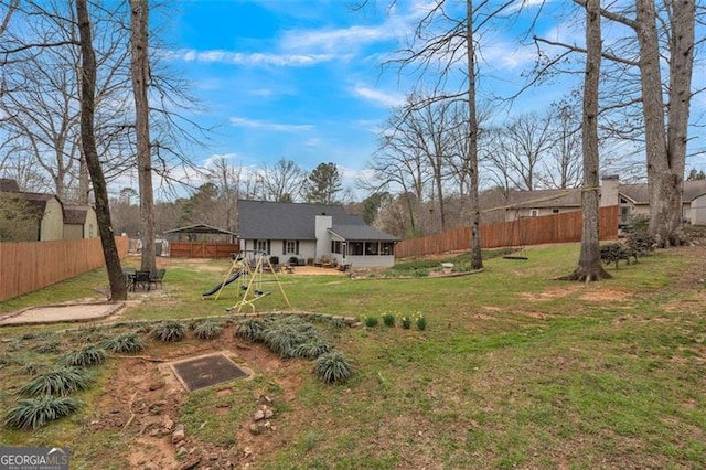 view of yard featuring a sunroom and fence