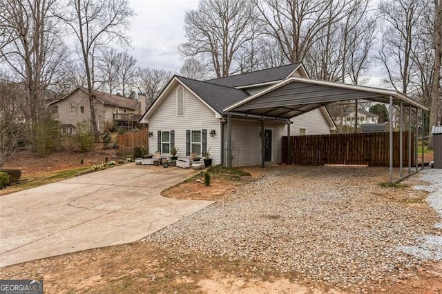 view of front facade featuring a carport, gravel driveway, and fence