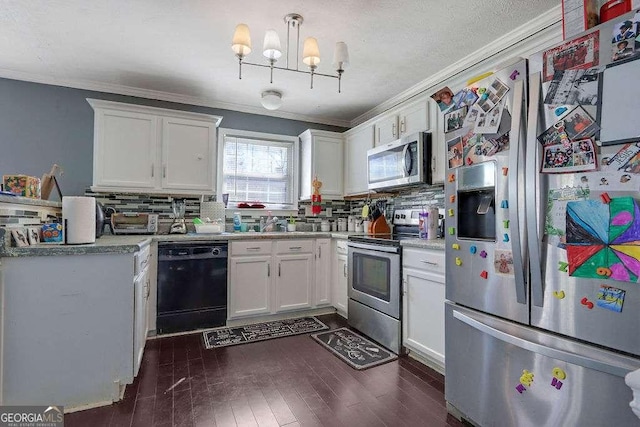 kitchen featuring appliances with stainless steel finishes, white cabinets, light countertops, and ornamental molding