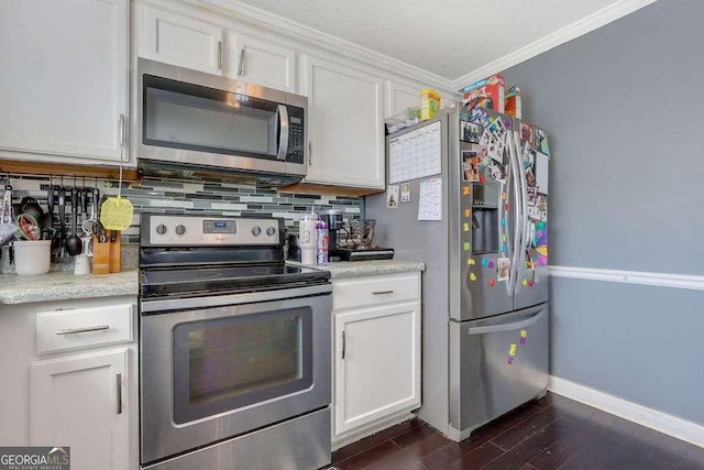 kitchen with white cabinets, light countertops, appliances with stainless steel finishes, dark wood finished floors, and crown molding