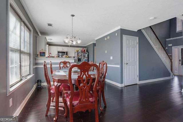 dining area featuring dark wood-style floors, an inviting chandelier, visible vents, and crown molding