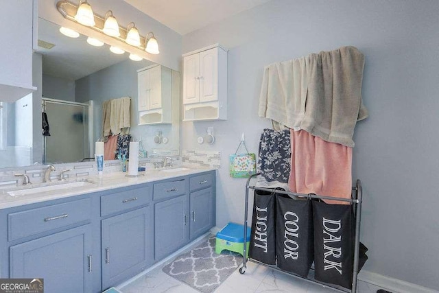 full bath featuring a stall shower, marble finish floor, a sink, and double vanity