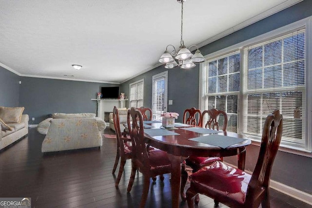 dining room with an inviting chandelier, wood-type flooring, ornamental molding, and baseboards