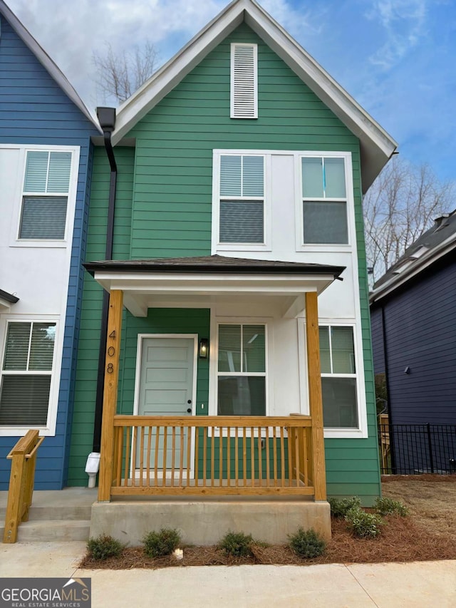 view of front of property with covered porch and fence