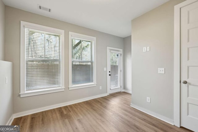 entrance foyer with baseboards, visible vents, and wood finished floors