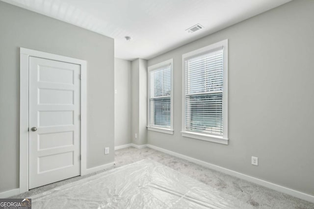 empty room with baseboards and visible vents