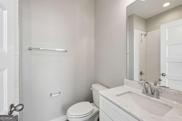 full bathroom featuring toilet, baseboards, walk in shower, and vanity