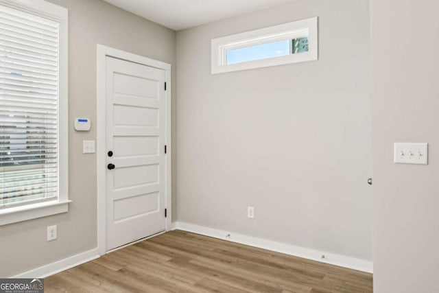 foyer entrance featuring baseboards and wood finished floors