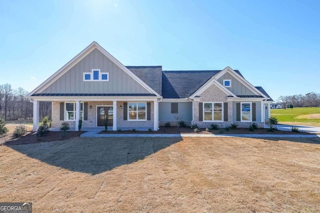 craftsman-style house featuring a front lawn, board and batten siding, and brick siding