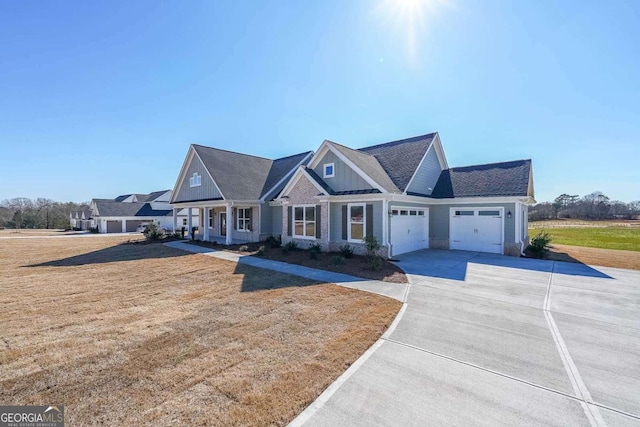 craftsman-style home with board and batten siding, a front yard, driveway, and a garage